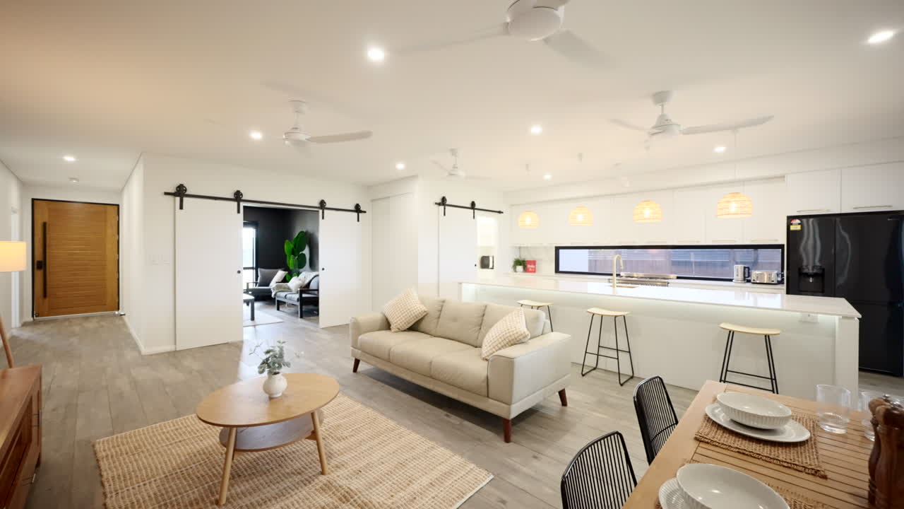 Ampia casa modello con arredamento di design moderno, open space, vista d'insieme su tappeto in fibra naturale e tavolo da pranzo, completamente allestita