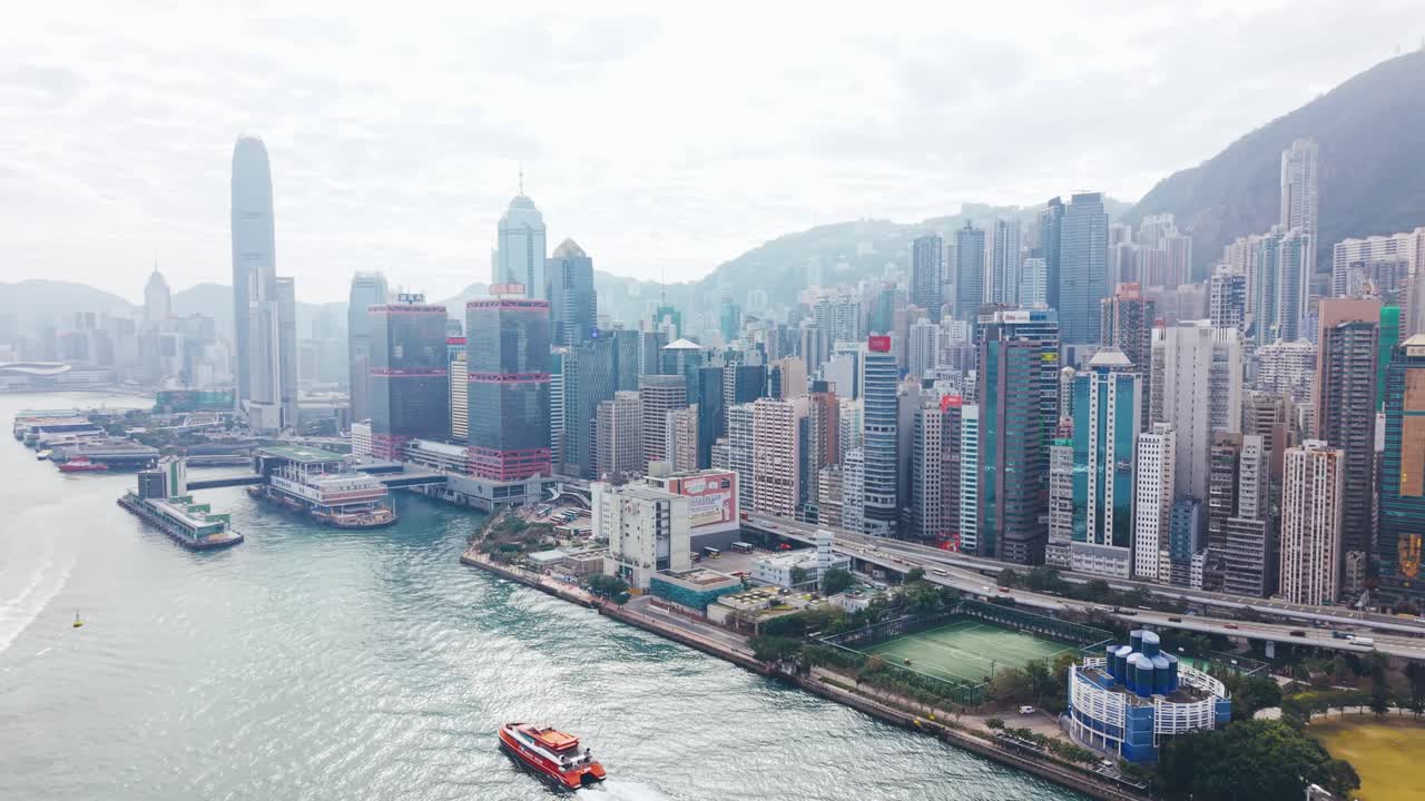 Letecký pohled na panorama Hongkongu z přístavu Victoria, s hustými mrakodrapy tyčícími se podél nábřeží a tvořícími jednu z nejikoničtějších městských scenérií Asie. (4)