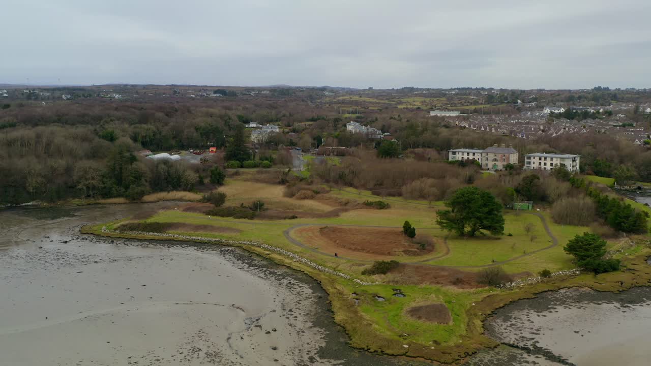 Wide aerial descending dolly shot of Lough Rusheen headland, home to Galway and Claddagh Swan Sanctuary.
