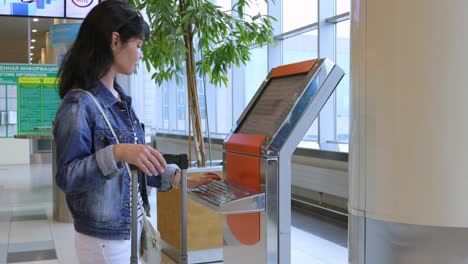 Check-in-De-Viajero-Femenino-En-El-Mostrador-De-Autoayuda-En-El-Aeropuerto