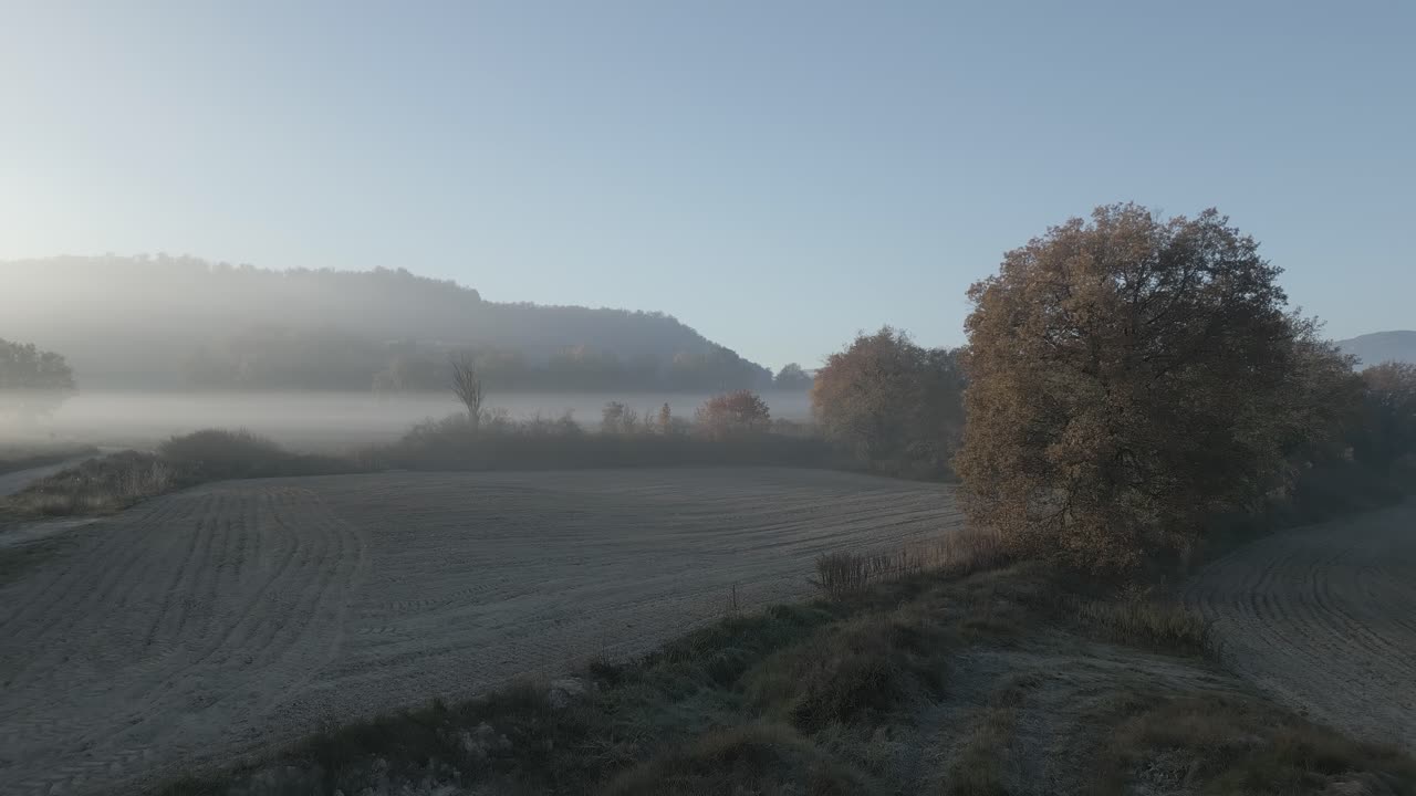 paisaje de niebla aérea sobre campos agrícolas secos malla barcelona españa tona, fondo de montaña y árboles amarillos, en español panorámico, drone aéreo en cámara lenta