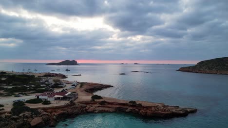 Atemberaubende-Luftaufnahme-Von-Oben,-Flug,-Sonnenuntergang,-Bewölkter-Himmel,-Strand,-Ibiza,-Spanien,-Cala-Comte