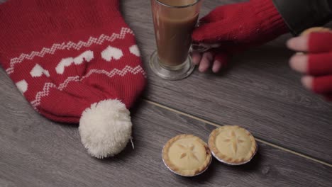 mano usando guantes de invierno agarrando pasteles y café