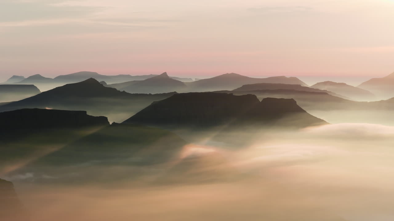 Mountain peaks emerging from a sea of fog at sunrise