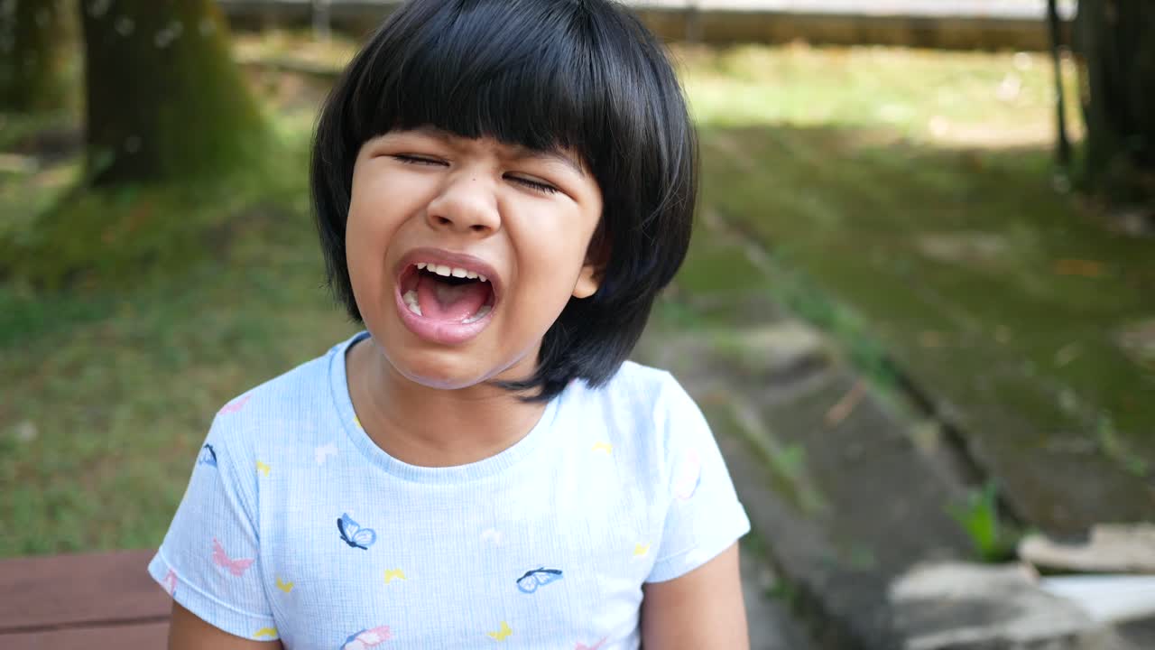 Una bambina triste che guarda in basso