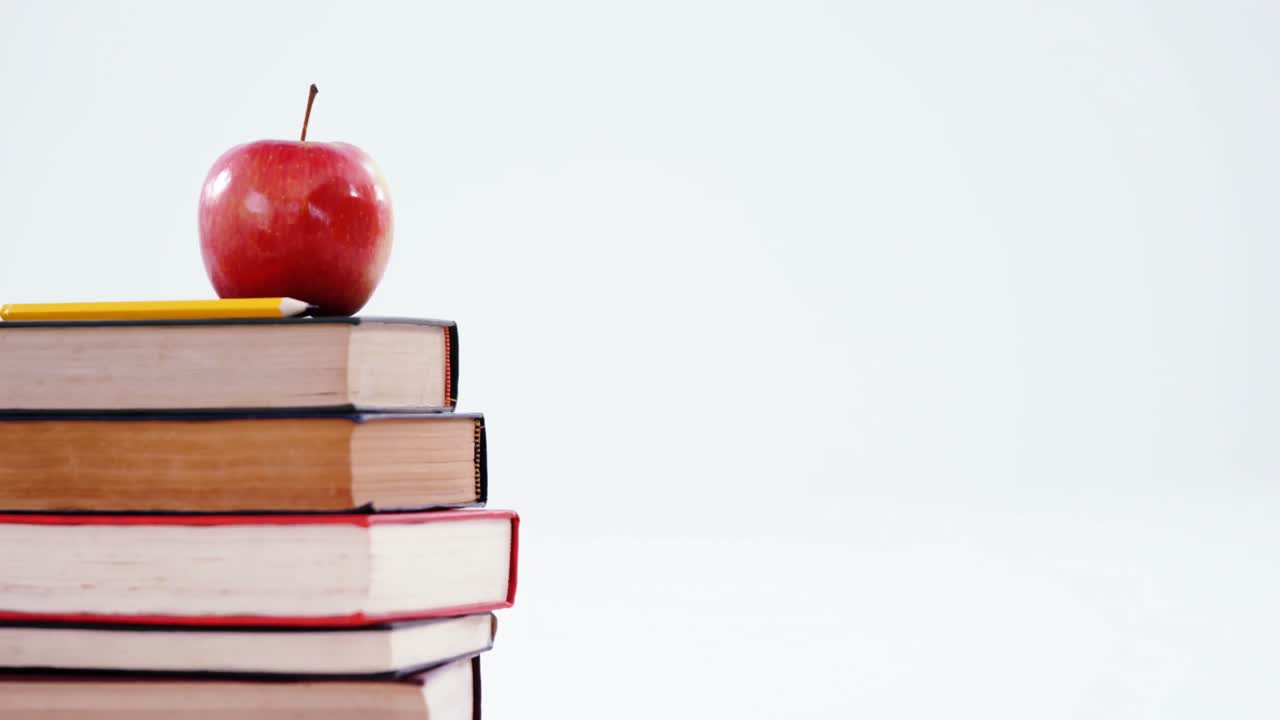 Apple and color pencil on book stack
