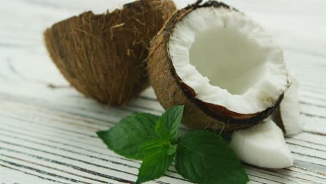 mitades de coco fresco con hojas de menta