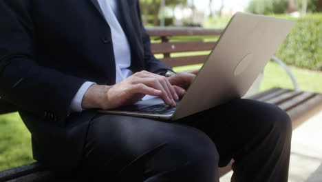 un homme assis sur le banc d'un parc