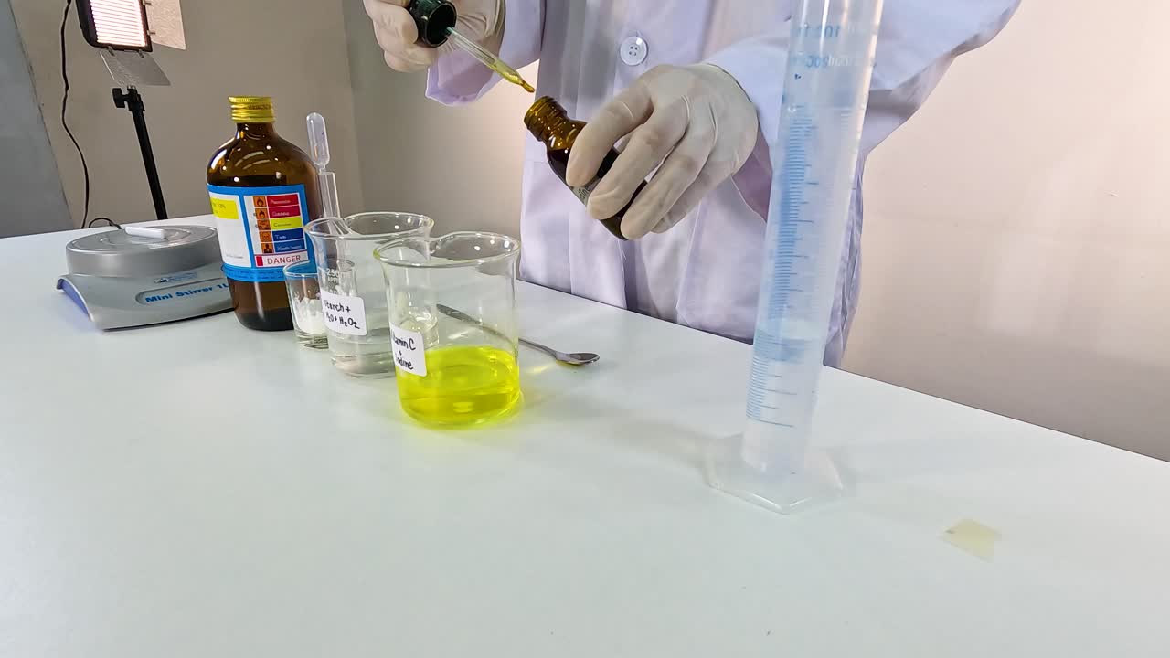 Scientist conducts iodine clock reaction using chemicals in a lab setting. Bright lighting highlights the precise mixing process