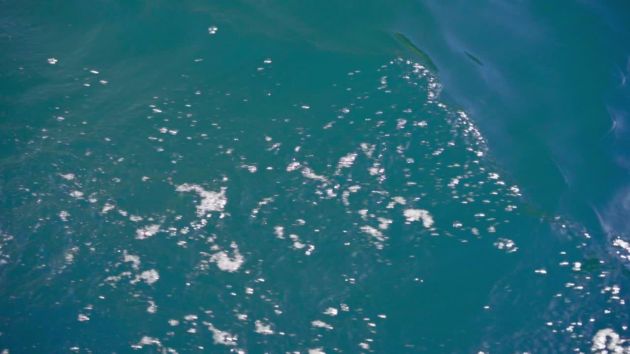 夏に海を航行するボートの側面から波