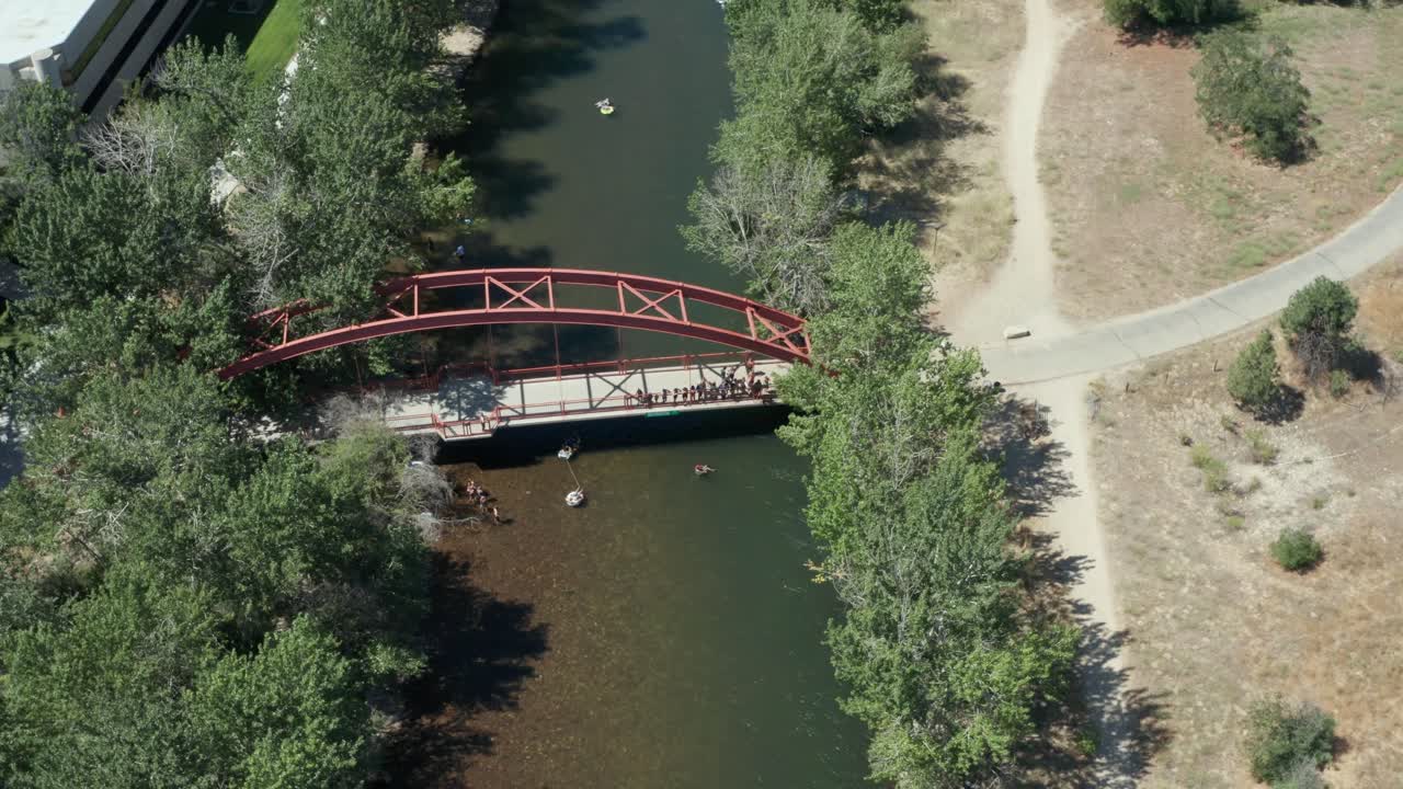 Dronekuvaa ihmisistä hyppäämässä punaiselta sillalta Boise-jokeen.