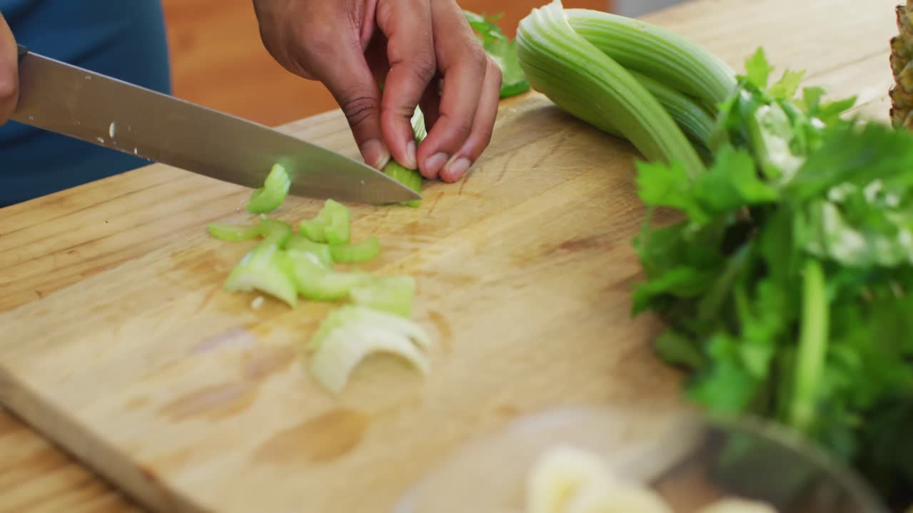 Fit african american man cooking, preparing healthy green smoothie