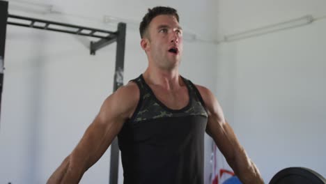 hombre caucásico en forma entrenamiento, ejercicio, levantamiento de pesas dentro del gimnasio