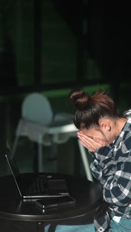 mujer joven trabajando en una computadora portátil en un café