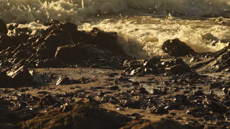 Rough-Sea-Waves-Crashing-On-Rocky-Shoreline-During-Golden-Sunset---Close-Up-Static-Shot