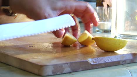 una mujer corta un limón en una tabla de cortar de madera