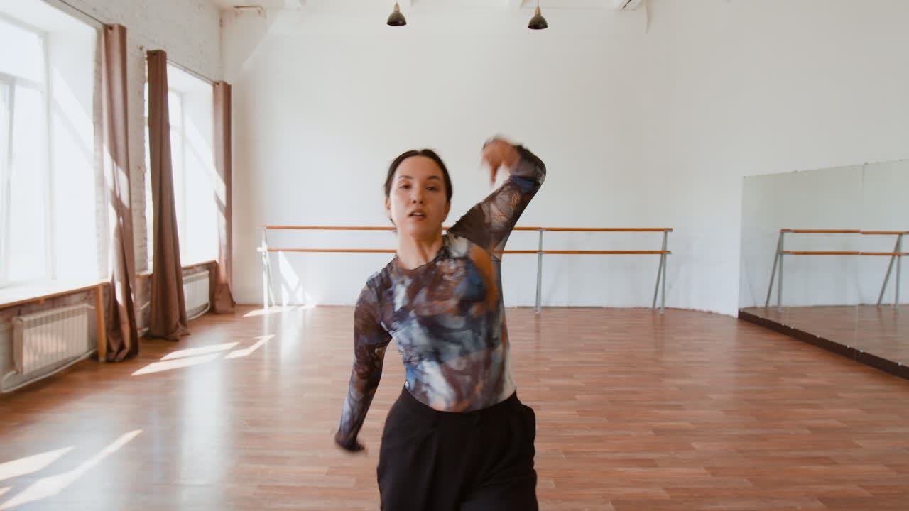 Woman practicing contemporary dance in a spacious studio