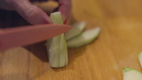 closeup of apple slices being trimmed on a cutting board