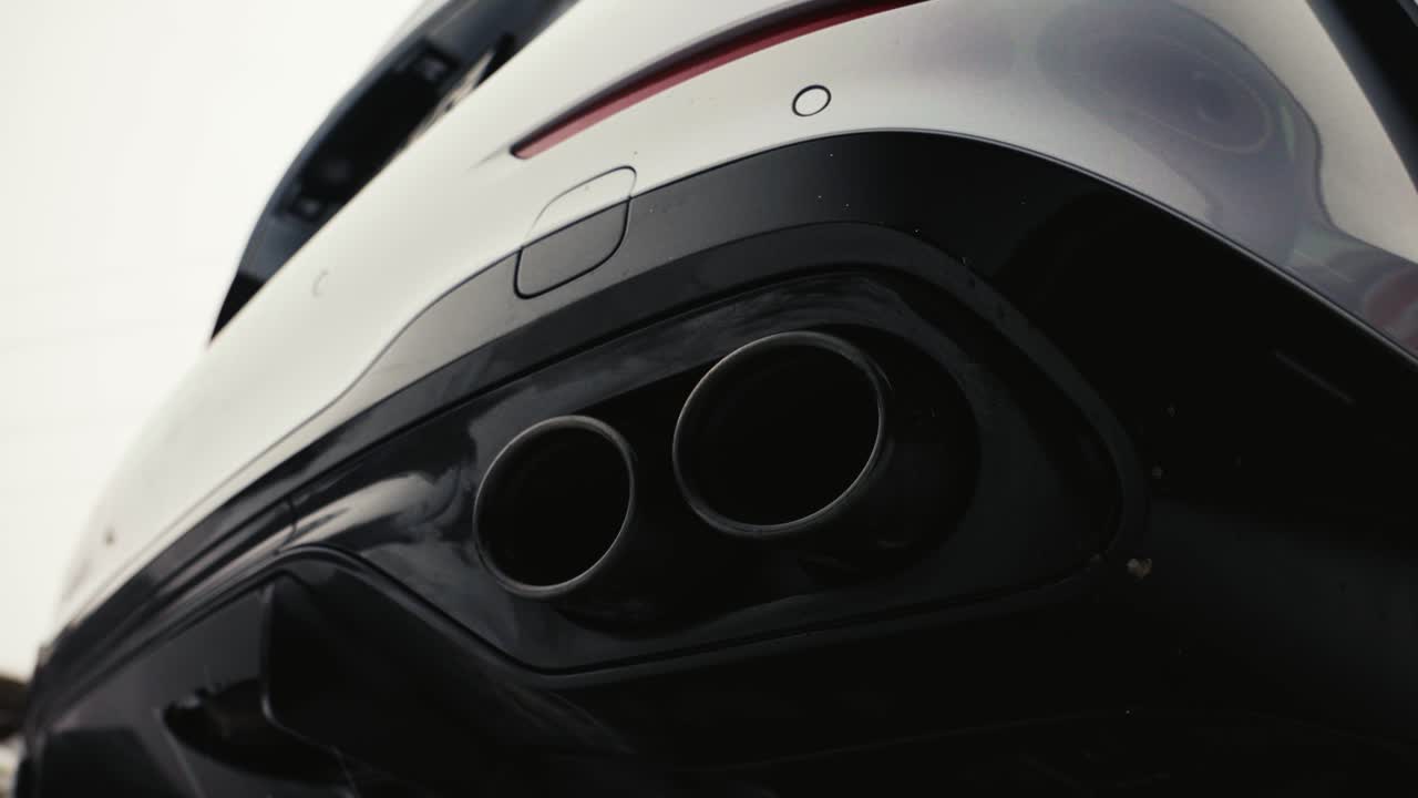 차의 검은색과 색 뒷 버퍼와 둥근 배기가스 파이프의 낮은 각도 시각