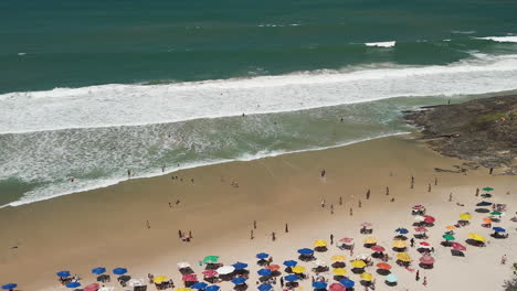 aerial view of crowded beach with colorful umbrellas