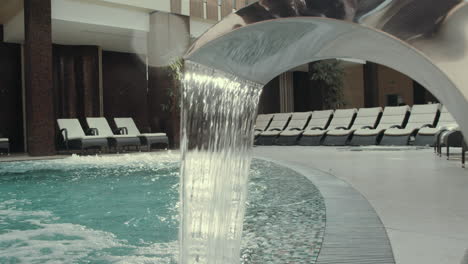 waterfall jacuzzi in hotel spa. water stop flowing hydromassage fountain in pool