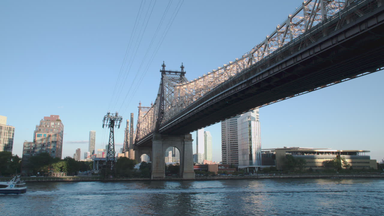 A New York City ferry passing beneath the Queensboro Bridge. Shot on an autumn day in New York City