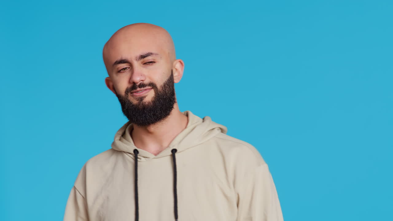 Arab male model doing no symbol on blue backdrop