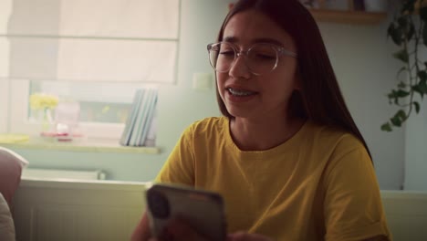 Caucasian-teenage-girl-having-video-call-while-spending-time-on-the-bedroom