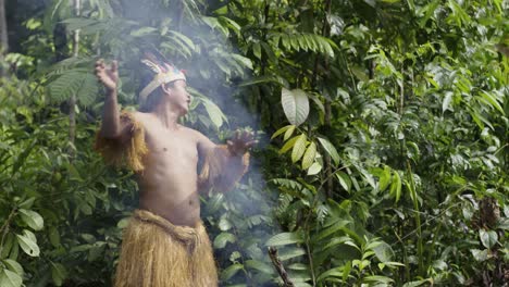 an indigenous guy performs a ritual using smoke in the dense forest of leticia, amazon, colombia