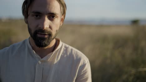 man meditating in a field at sunset