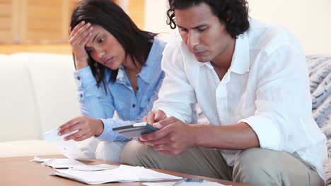 frustrated couple calculating their expenses