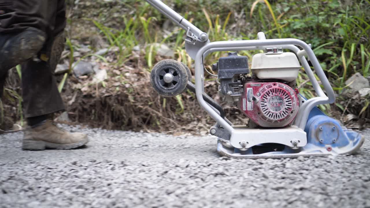 Compacting gravel with a plate compactor