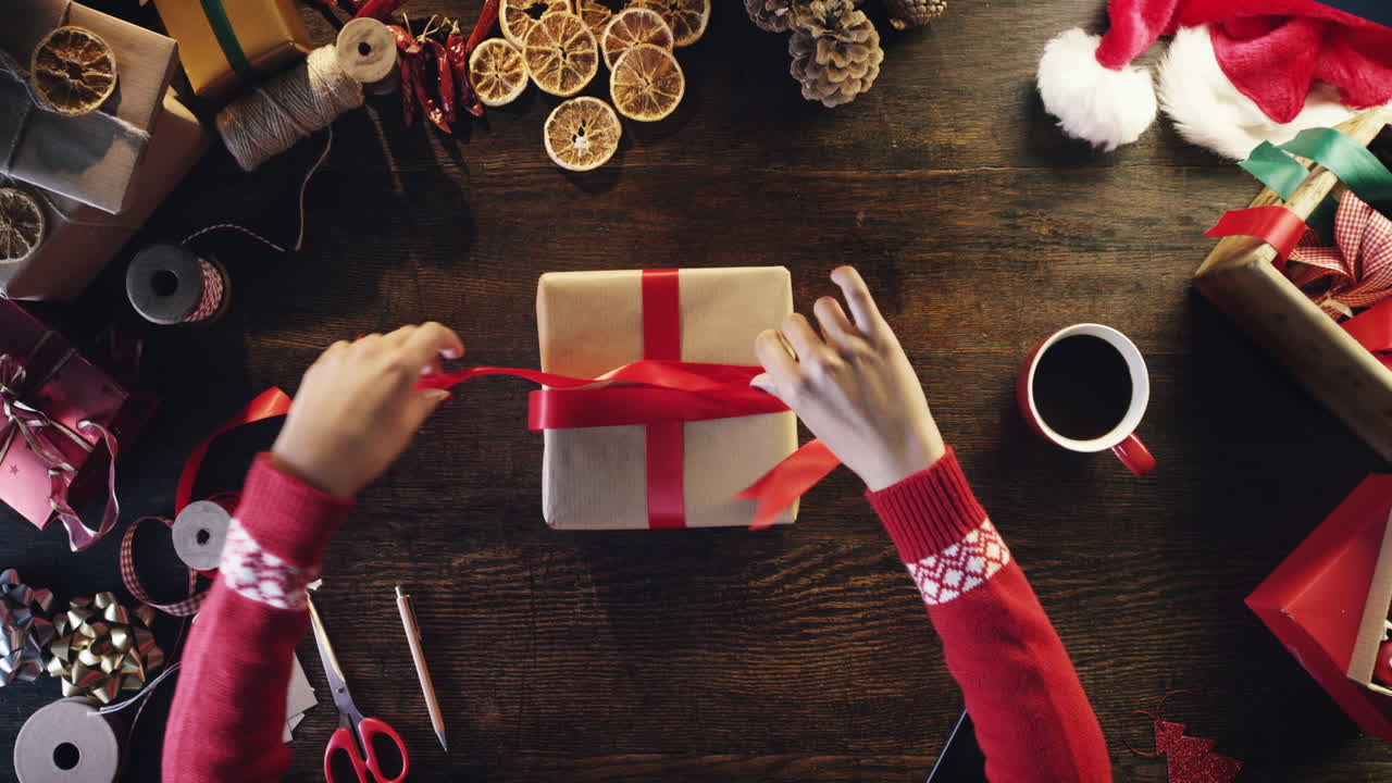 위쪽 에서 나무 책상 에 크리스마스 선물 을 포장 하는 여자 -  ⁇ 은 서사시 드래곤
