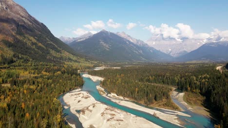 breathtaking-dolly-backwards-wide-shot-of-Mount-Robson-Provincial-Park-in-the-autumn-on-a-mix-of-sun-and-clouds-day-with-mountains-in-the-background-and-the-Fraser-River-in-front-surrounded-by-forest