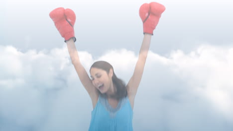 animación del cielo con nubes sobre una mujer biracial con guantes de boxeo celebrando