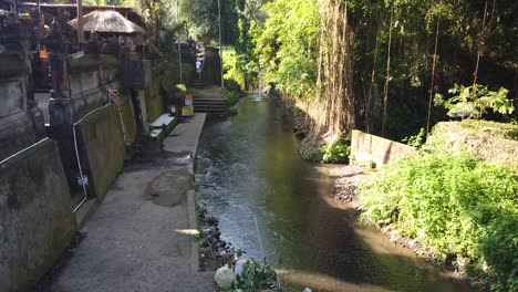 templo exhibido en el río junto a un bosque soleado en bali indonesia, ceremonia para orar en el hinduismo balinés