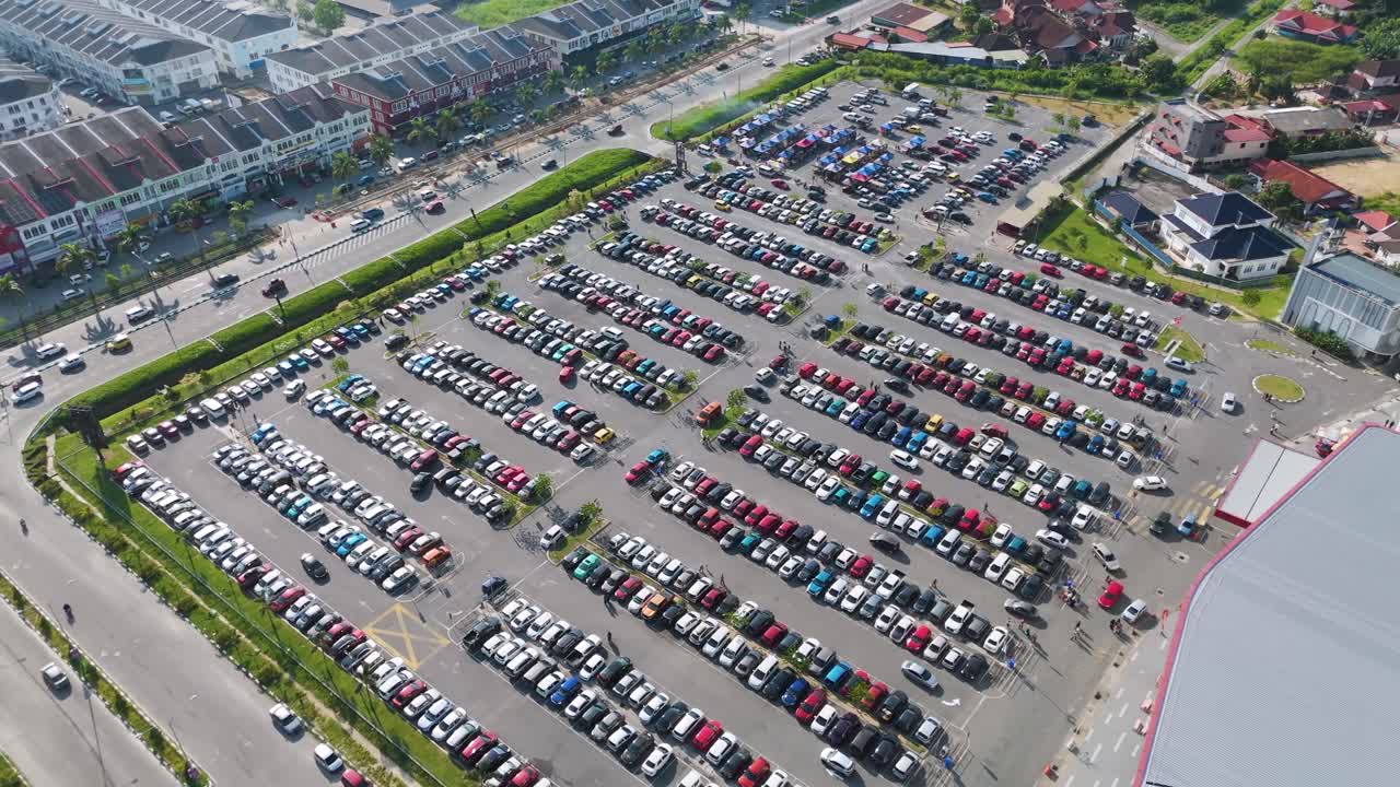 Aerial: car parking of shopping mall MyDin during the day in Kota Bharu, state of Kelantan, Malaysia, orbit drone shot