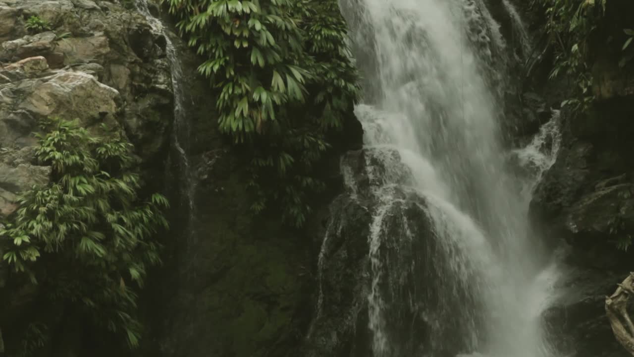 Tilt down on a beautiful and untouched waterfall in the Sierra Nevada de Santa Marta, Colombia. Wild nature