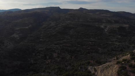 AERIAL:-Mediterranean-countryside-of-dark-valley-between-greek-hills