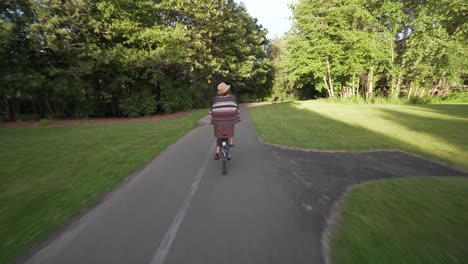 Girl-riding-bicycle-on-local-bike-path-follow-from-behind