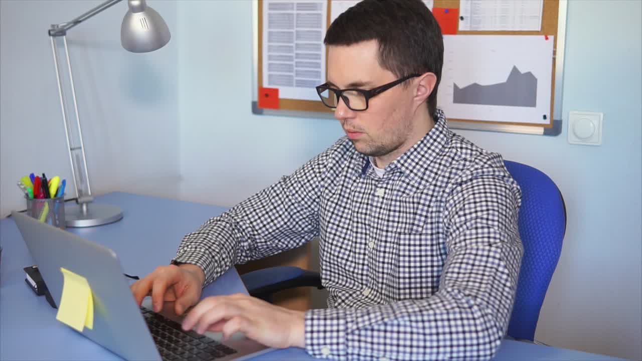 Hombre que trabaja en la computadora portátil en la oficina