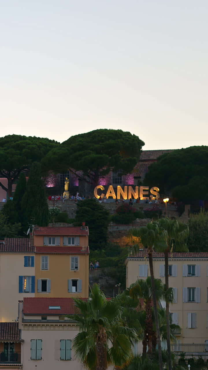 Cannes sign written with light bulbs on a top of a mountain in the Notre Dame d'Esperance church in the evening. Vertical, Cannes, France