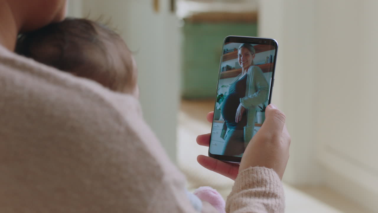 madre y bebé felices hablando por video usando un teléfono inteligente hablando con una amiga embarazada mostrando el vientre compartiendo el estilo de vida de la maternidad en el teléfono móvil