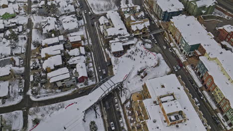 Park-City-Utah-Aerial-v75-birds-eye-view-elevation-shot-capturing-snow-covered-town-center-and-hillside-homes-surrounded-by-Wasatch-mountain-ranges-in-winter---Shot-with-Mavic-3-Cine---February-2023