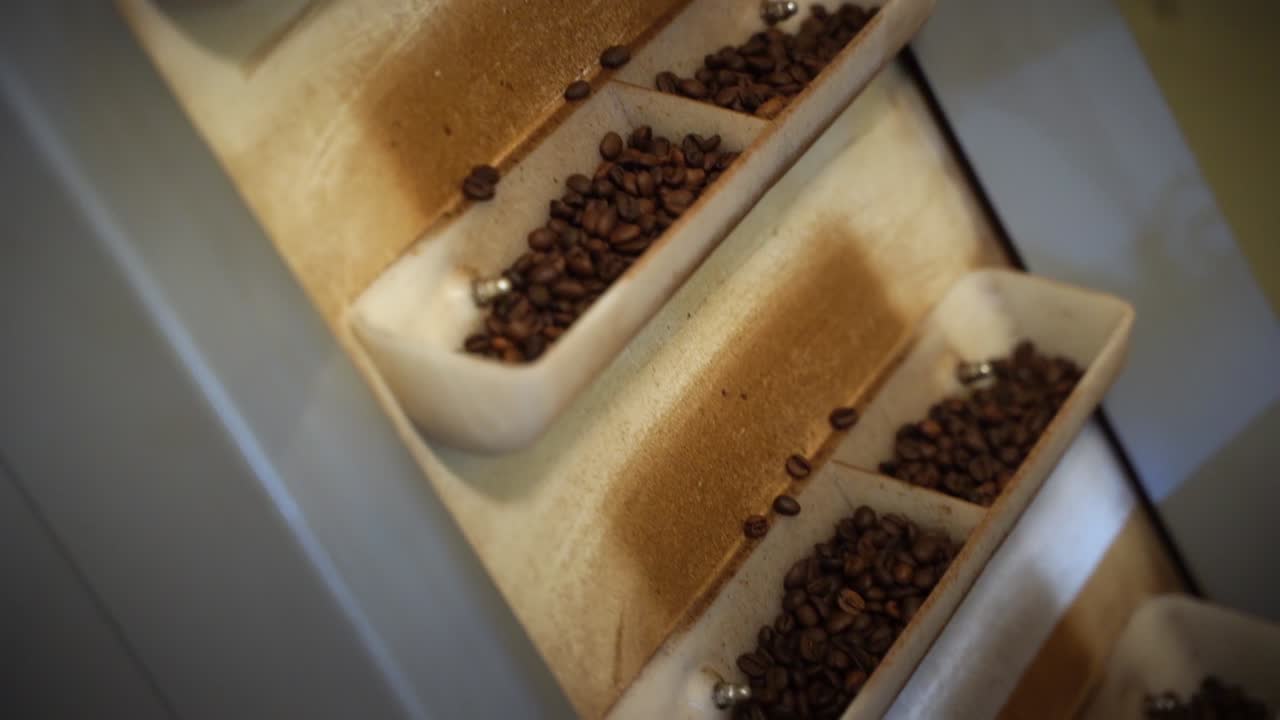 Industrial machine selecting and spinning roasted coffee beans, close up view