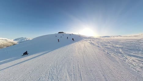 fast reverse dolly past skiers skiing towards camera, myrkdalen ski resort, norway