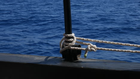 primer plano de un bote con una cuerda enrollada en la cubierta, fondo tranquilo de mar abierto