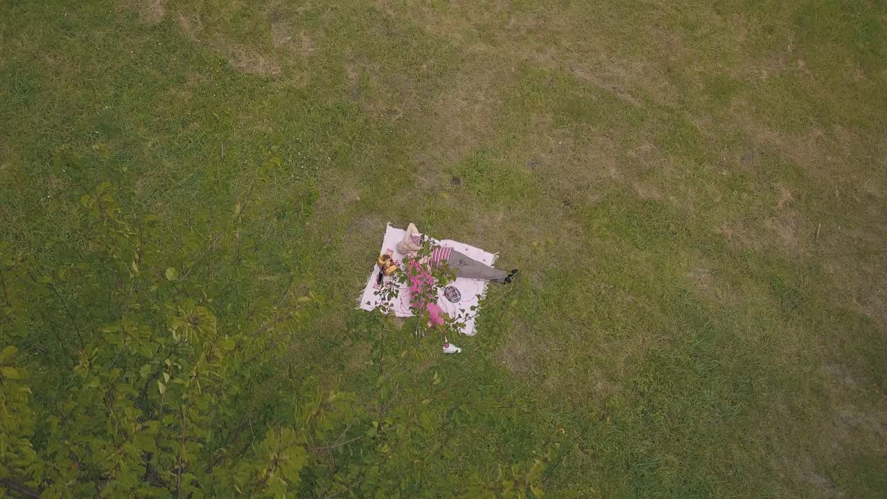 공원에서 주말 가족 피크닉. 공중 풍경. 노인 부부가 녹색 잔디 잔디에 담요에 누워