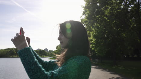 Pretty-Italian-Woman-Tourist-Taking-Photograph-of-a-Park-in-Wimbledon-London