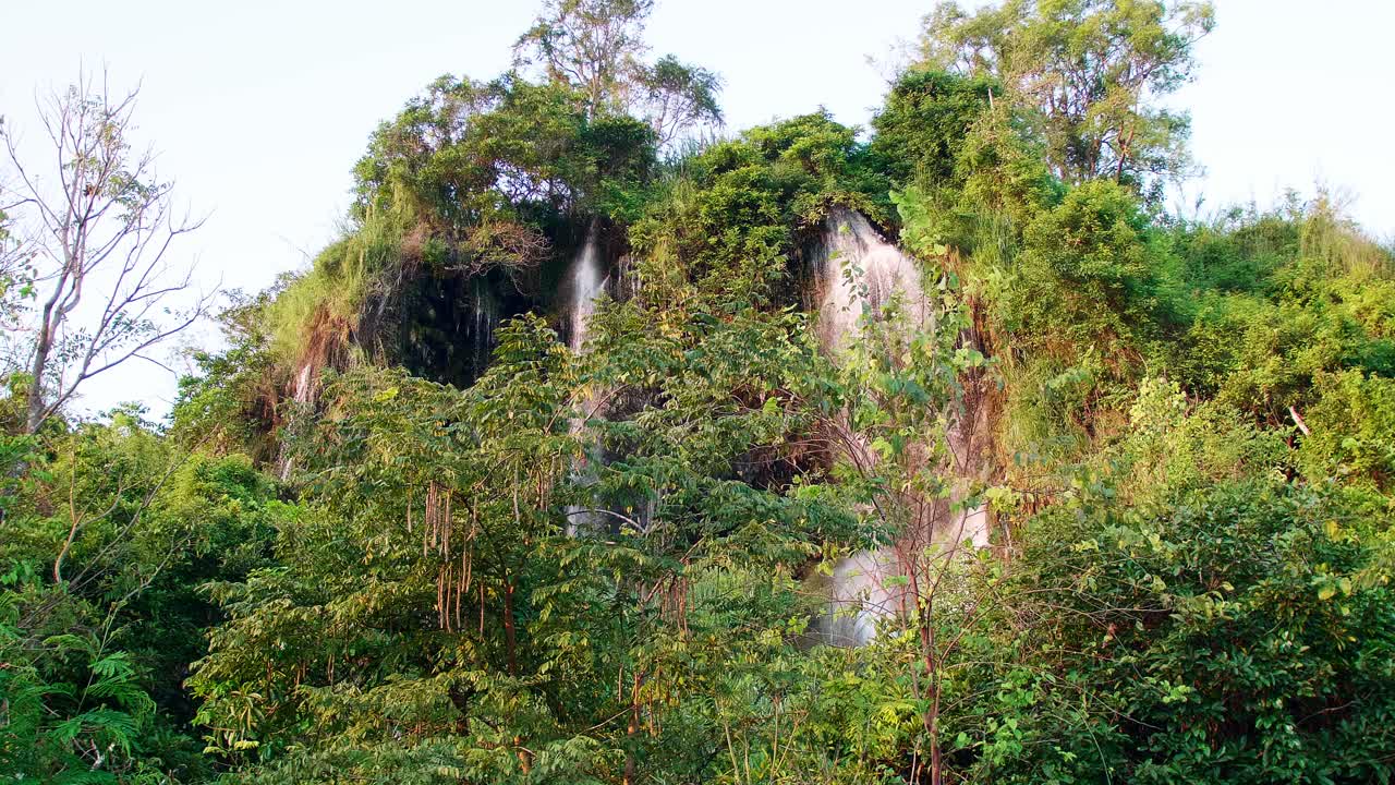 la cascada natural que fluye por la montaña está iluminada por el sol vespertino